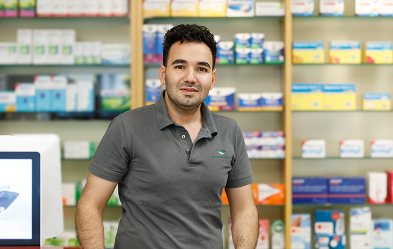 Chef der Trierweiler Apotheke steht vor einem Medikamentenregal.