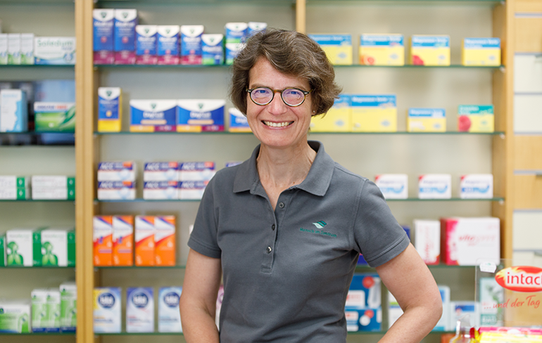 Apothekerin der Trierweiler Apotheke steht vor dem Medikamentenregal.