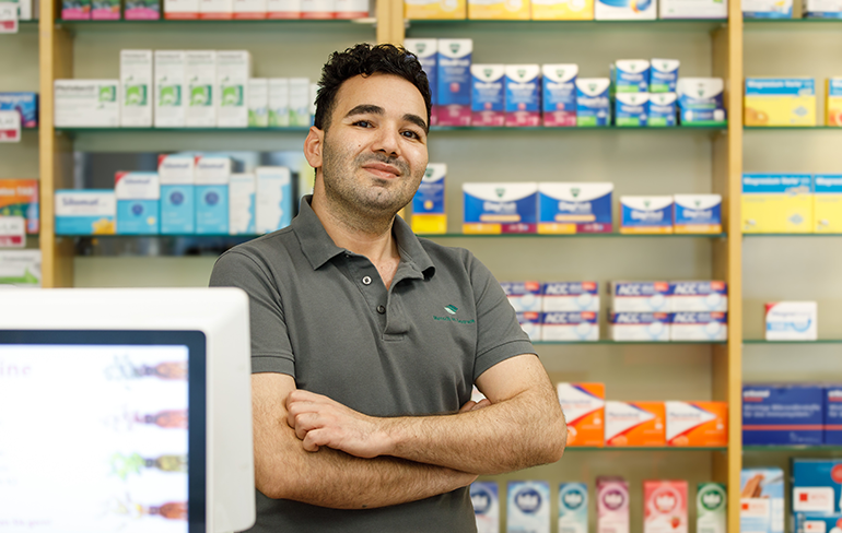 Apothekerin der Trierweiler Apotheke steht vor dem Medikamentenregal.