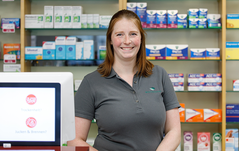 Apothekerin der Trierweiler Apotheke vor dem Medikamentenregal.