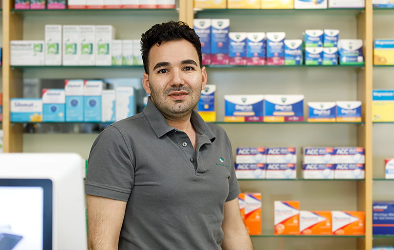 Chef der Trierweiler Apotheke steht vor dem Medikamentenregal.