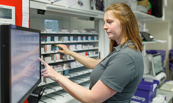 Apothekerin der Trierweiler Apotheke vor dem Medikamentenregal.
