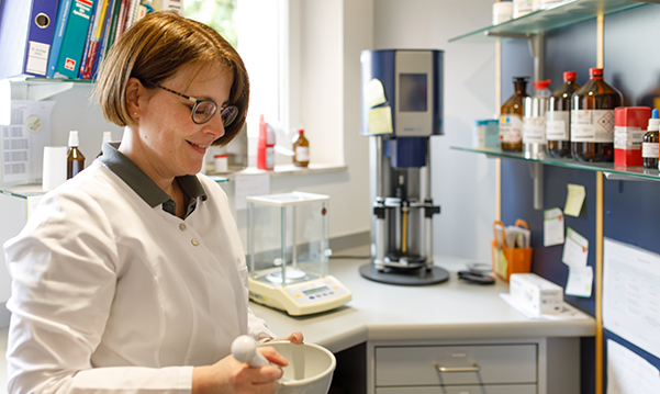 Apothekerin der Trierweiler Apotheke vor dem Medikamentenregal.